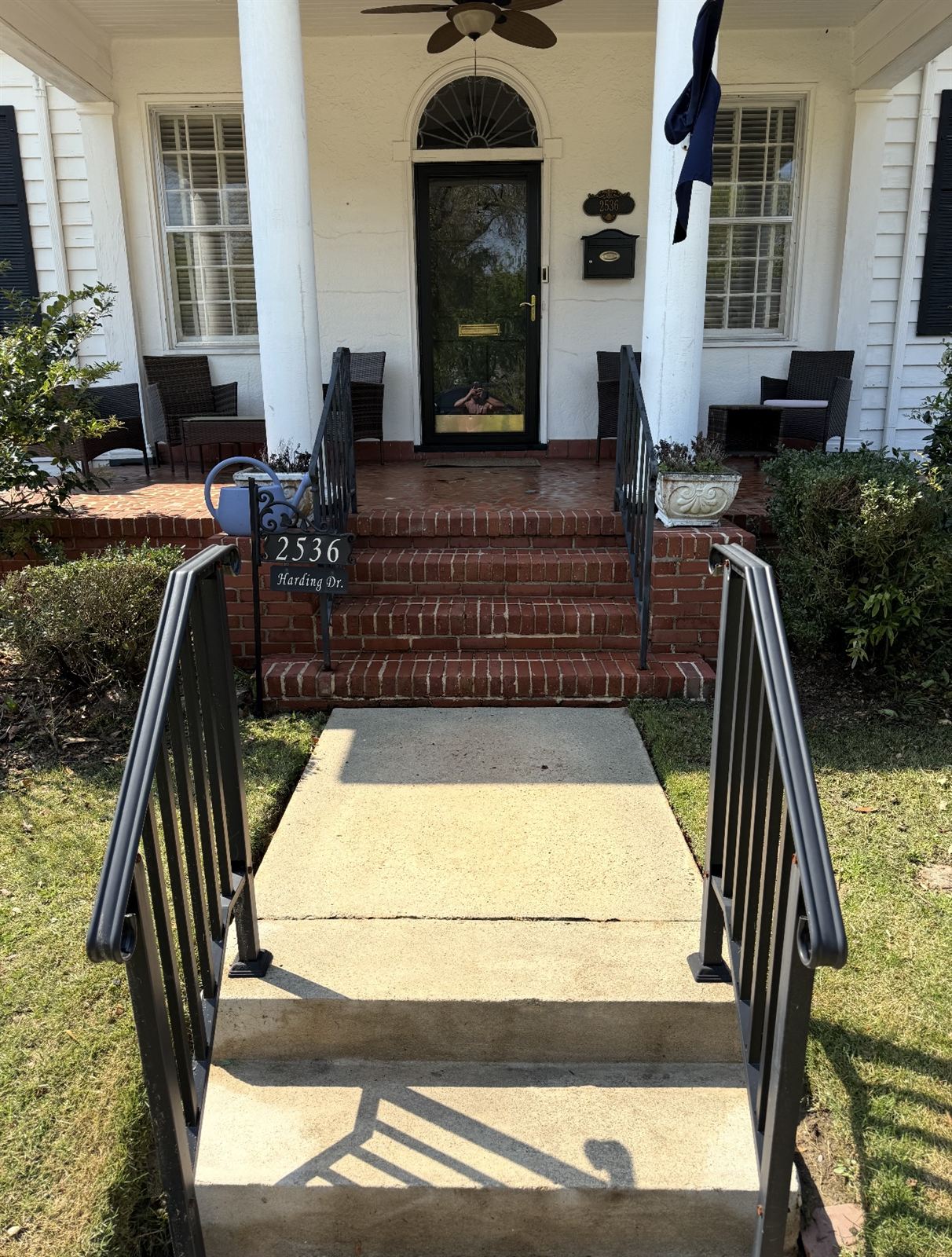 Clean concrete walkway and bright red brick steps after pressure washing in Columbus, GA