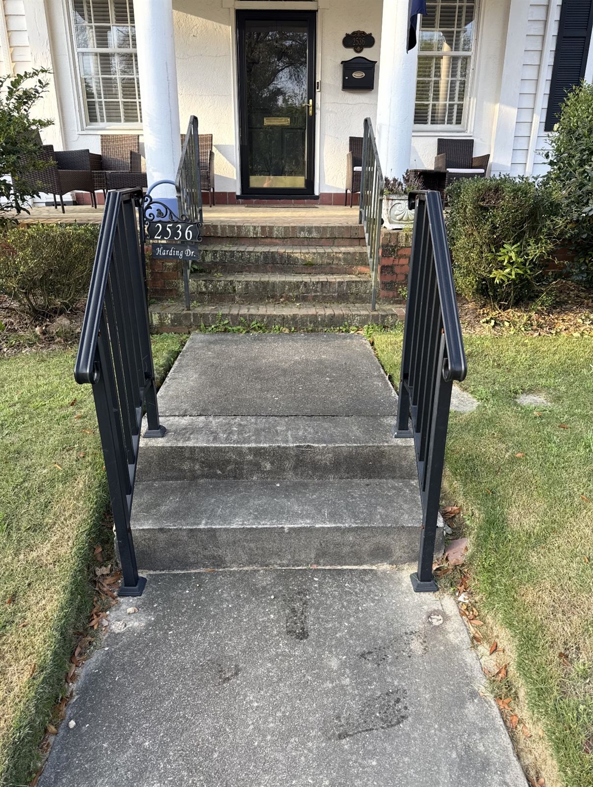 Darkened concrete walkway and grimy brick steps before pressure washing in Columbus, GA
