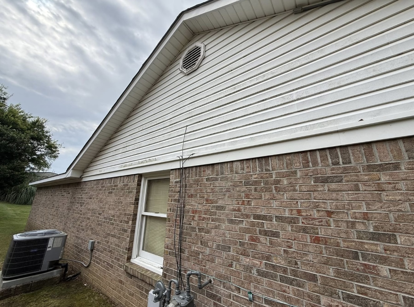 Dirty streaked vinyl siding and brick before house washing in Columbus, GA